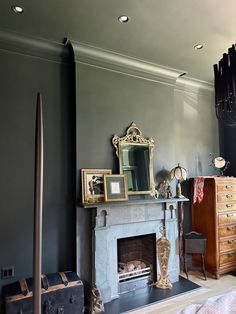 a living room with a fireplace, dresser and mirror