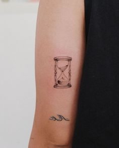 a woman's arm with a tattoo that has an hourglass on it and the word mac written in cursive writing