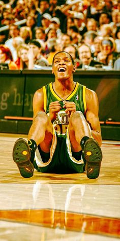 a basketball player sitting on the court with his mouth open