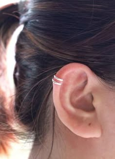 a close up of a person's ear with a ring on top of it