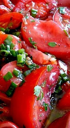 a salad with tomatoes, green onions and parsley on the side is ready to be eaten