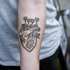 a black and white heart tattoo on the arm