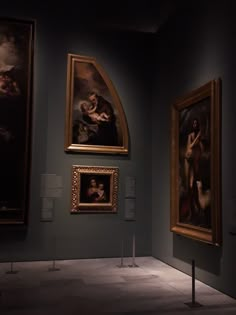 three paintings on display in a museum with one being a woman and the other is a man