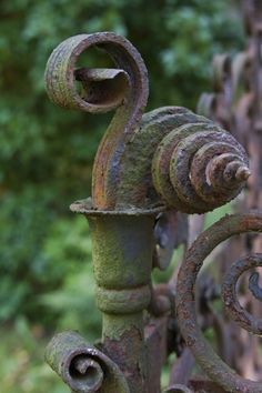 an old iron gate with vines and leaves on it