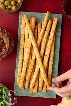 french fries on a plate with olives and breadcrumbs in the background