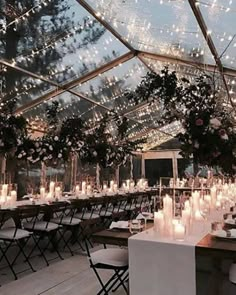 an indoor tent with tables and chairs covered in candles