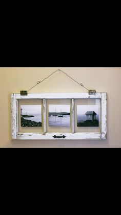 an old window frame hanging on the wall with three pictures hung to it's sides