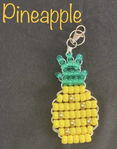 a pineapple keychain made out of legos on a black surface with the words pineapple written across it