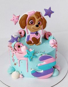 a birthday cake with a dog on top and stars around the edges is decorated in pastel colors