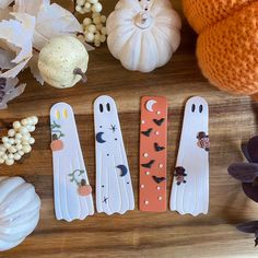 four halloween decorations are sitting on a table next to pumpkins and other decor items