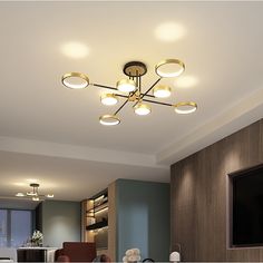 a living room filled with lots of furniture and lights on top of the ceiling next to a flat screen tv