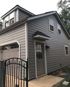 a gray house with a black gate in front of it