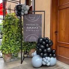 a welcome sign and balloons in front of a door with a basketball court on it