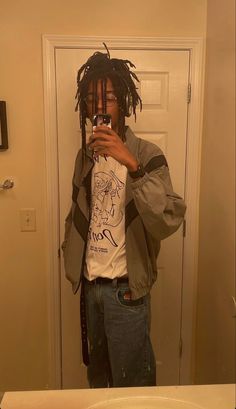 a man taking a selfie in front of a mirror with dreadlocks on