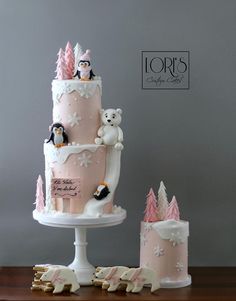 a three tiered cake with pink frosting and white icing, topped with two teddy bears