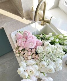 a sink filled with lots of flowers next to a faucet