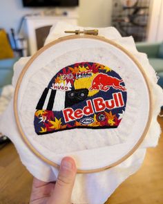 someone is holding up a red bull embroidery project