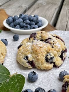 blueberry muffins with powdered sugar on top and fresh berries around them