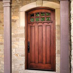 an image of a wooden door in front of a stone building with glass inserts