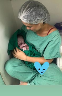 a woman in scrubs holding a baby