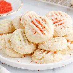 a plate full of sugar cookies with sprinkles on it next to other plates