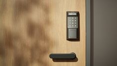 an electronic door handle on a wooden door with a keypad attached to the lock