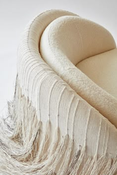 an upholstered chair with fringes on it