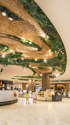 the interior of a shopping mall with plants growing on the ceiling