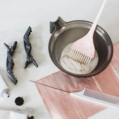 a hairbrush and comb sitting in a cup on a table next to other items