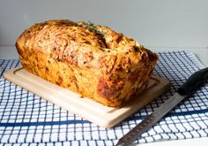 a loaf of bread sitting on top of a wooden cutting board next to a knife