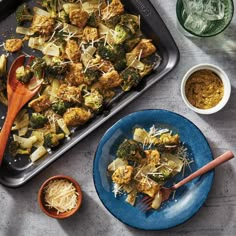 broccoli and cauliflower on a blue plate next to bowls of spices