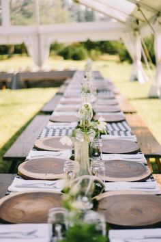 the long table is set with mason jars and place settings