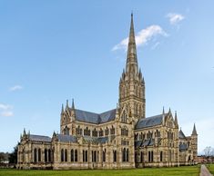 an old church with a steeple on the top and green grass in front of it