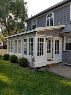 a gray house with white trim and windows