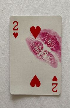 a playing card with two hearts and one kiss on the back of it, in red ink