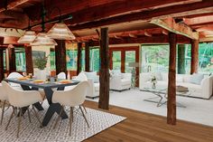 a large open living room with white furniture and wood beams on the ceiling is shown