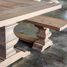 a close up of a wooden table with two benches in the middle and one bench at the end