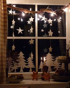 the window is decorated with christmas lights and stars on it's windowsills