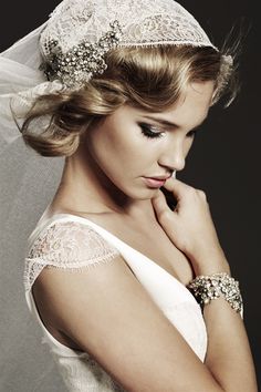 a woman in a wedding dress with a veil on her head and bracelet around her neck