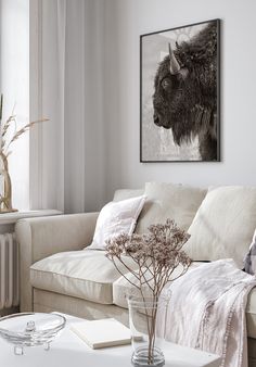 a living room filled with furniture and a painting on the wall above it's coffee table