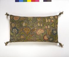 an embroidered pillow hanging on a wall