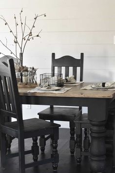 a dining room table with two chairs and a vase on it's centerpiece