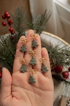 a person is holding some tiny christmas trees in their hand, with pine cones on them