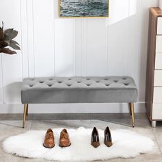 three pairs of shoes sitting on top of a rug in front of a white wall