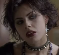 a close up of a person wearing necklaces and chokers on her neck with an open mouth