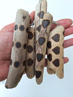 four pieces of wood with hearts on them being held by a person's hand