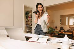 a woman standing in front of a laptop computer