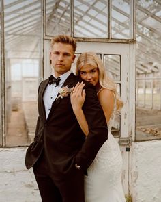 a man in a tuxedo standing next to a woman