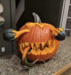 a carved pumpkin with teeth and fangs on it's head sitting on a counter