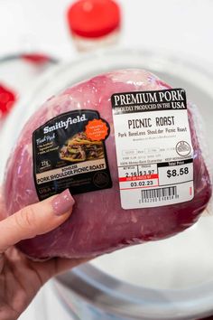 a person holding a piece of meat in their hand with the label on it that says pork roast